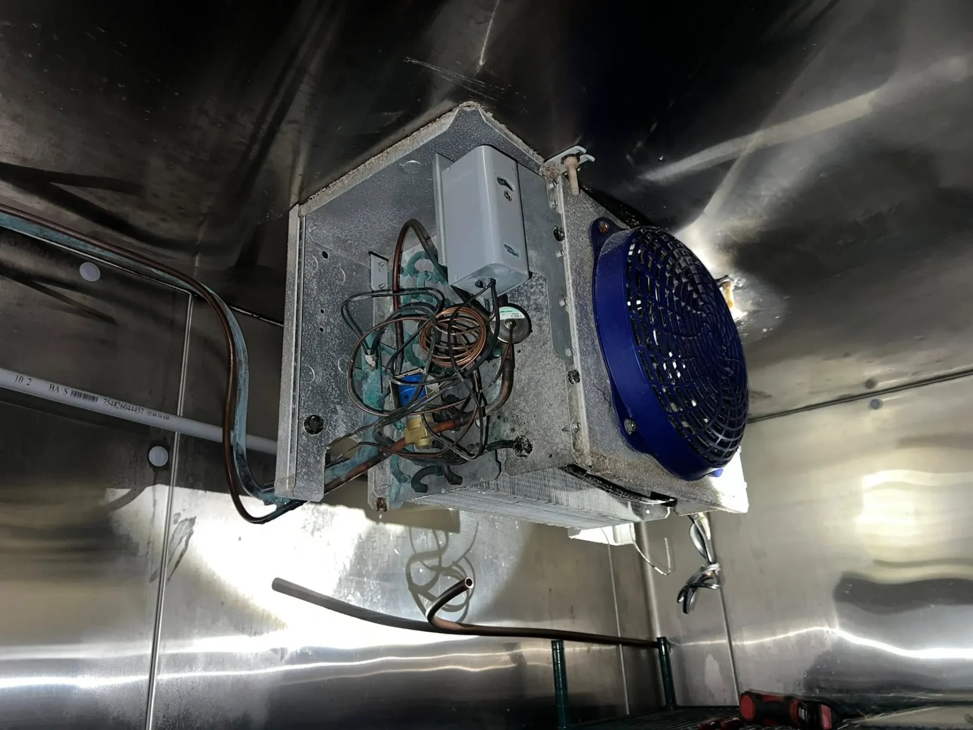Walk-in cooler evaporator unit and fan during repair